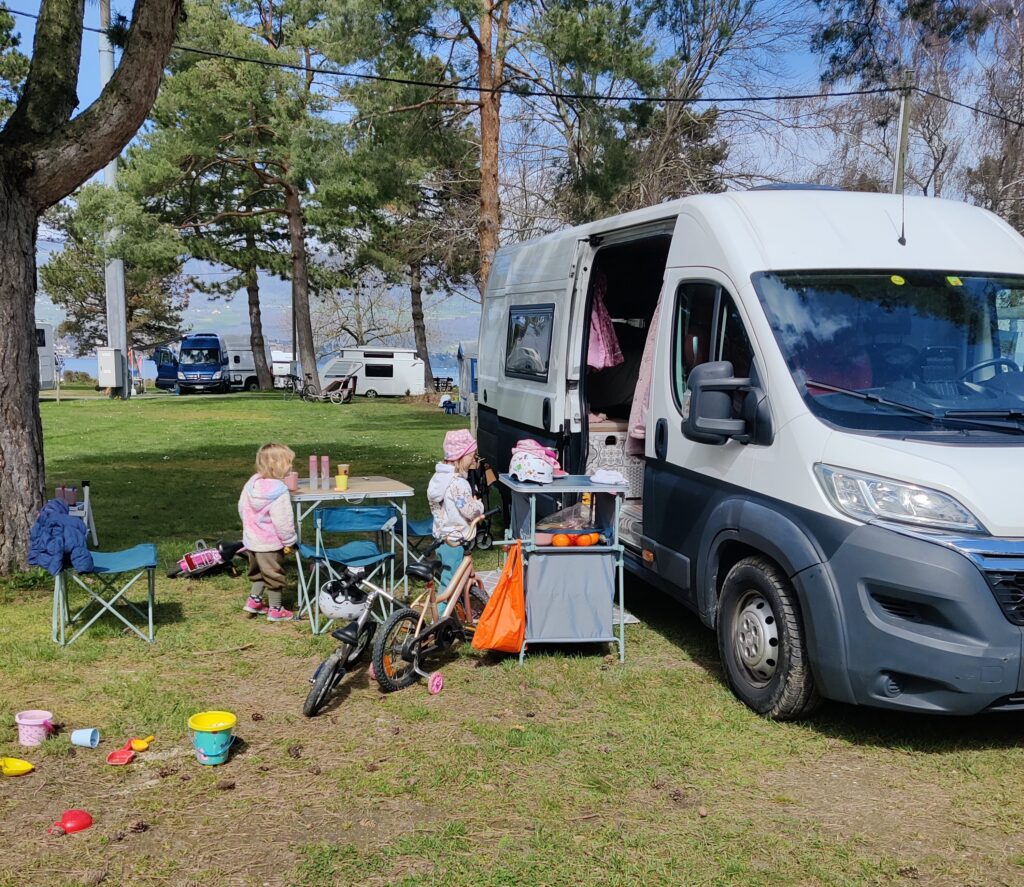 Der Stellplatz mit einem Van auf der Wiese beim Camping Yverdon Plage